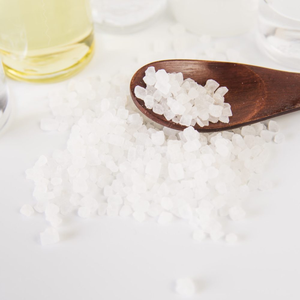 overhead-view-rock-salts-wooden-spoon-against-white-backdrop